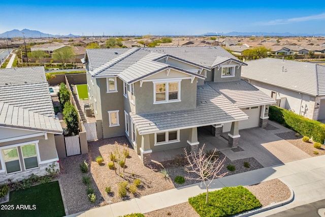 view of front of property with driveway, a tiled roof, a residential view, and stucco siding