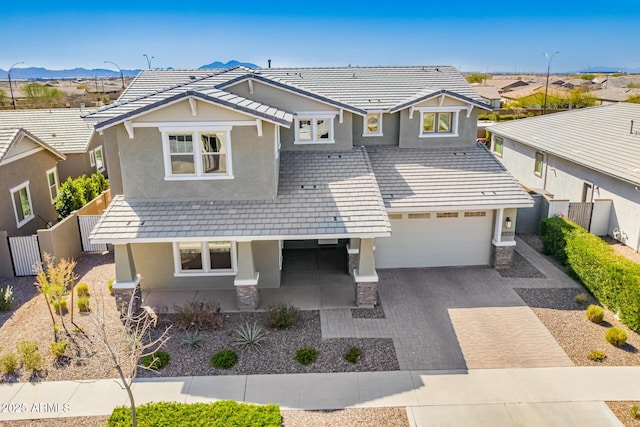 view of front of home featuring decorative driveway, stucco siding, fence, a residential view, and a tiled roof