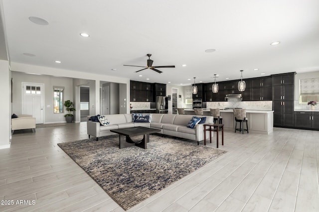 living area featuring wood finish floors, a ceiling fan, and recessed lighting