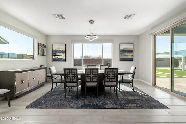 dining space featuring light wood finished floors, visible vents, and baseboards