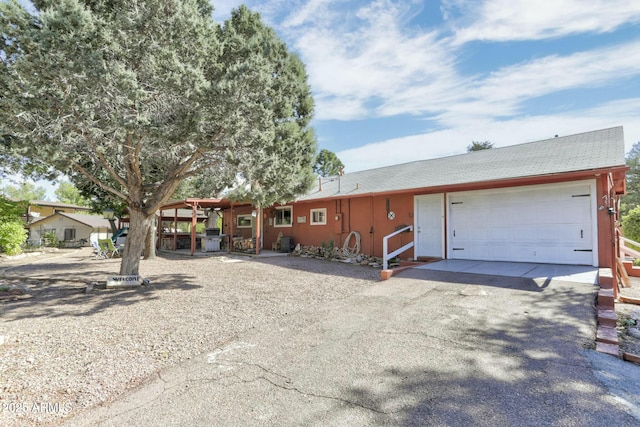 ranch-style home with roof with shingles and driveway