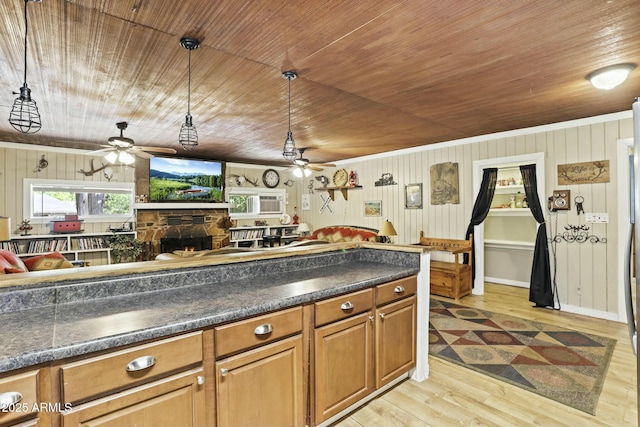 kitchen featuring light hardwood / wood-style flooring, decorative light fixtures, wooden walls, a fireplace, and wood ceiling