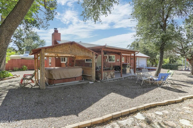 back of house with a patio and a hot tub