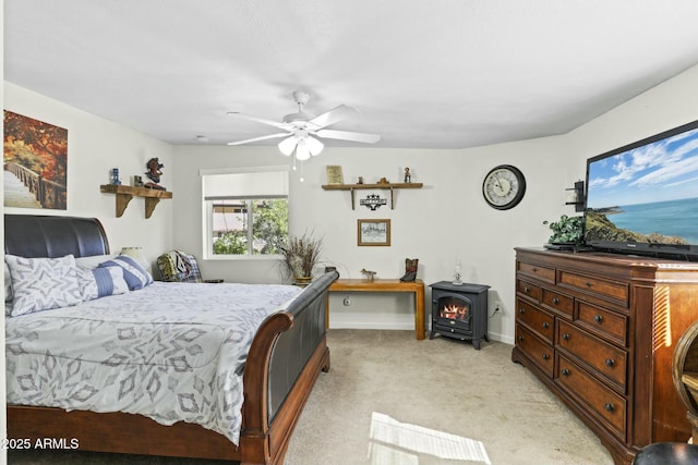 carpeted bedroom with ceiling fan and a wood stove