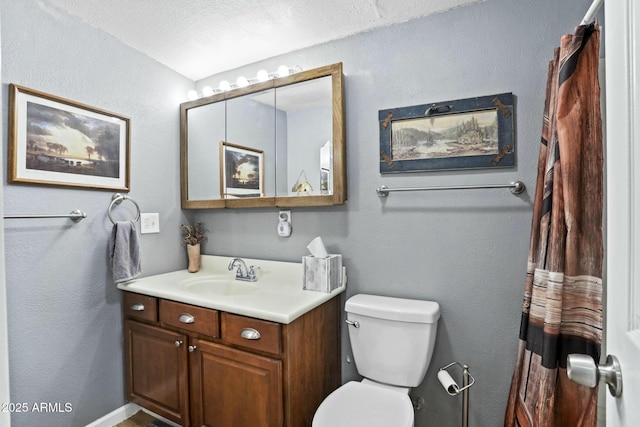 bathroom with vanity, a textured ceiling, and toilet