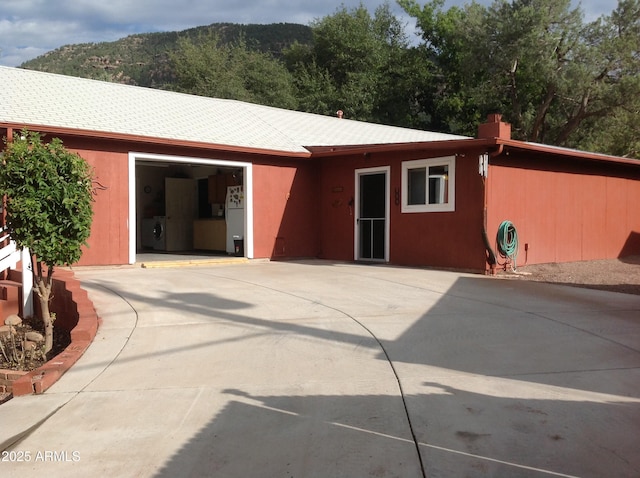 rear view of property featuring washer / clothes dryer, a mountain view, and a garage