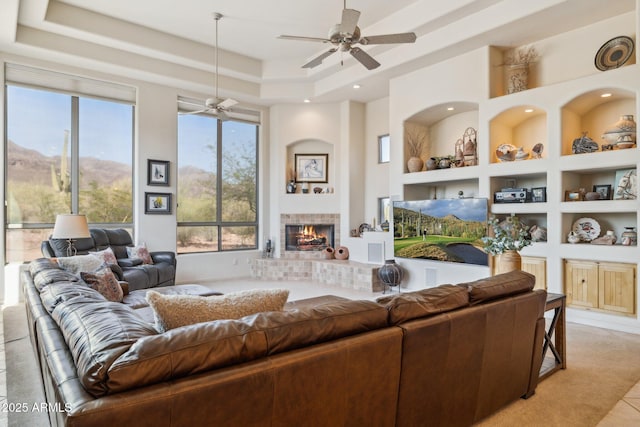 148 N La Barge Rd, Apache Junction, AZ 85119 - living area featuring ceiling fan, a fireplace, a raised ceiling, built in shelves, and recessed lighting