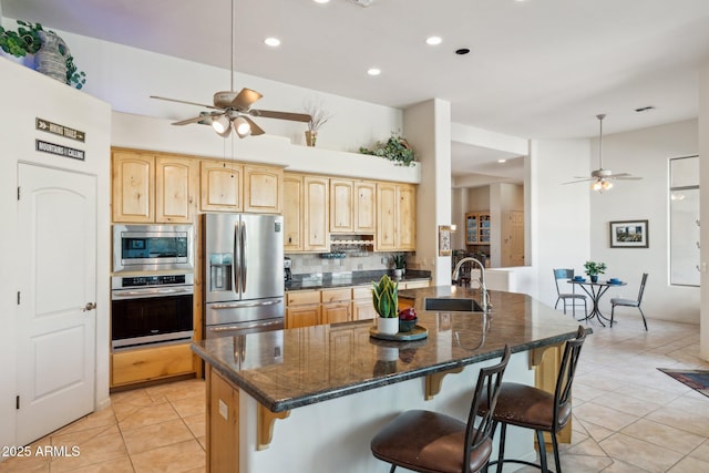 148 N La Barge Rd, Apache Junction, AZ 85119 - kitchen with appliances with stainless steel finishes, ceiling fan, light tile patterned flooring, backsplash, and a kitchen breakfast bar
