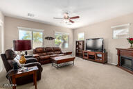 living room featuring a fireplace and ceiling fan
