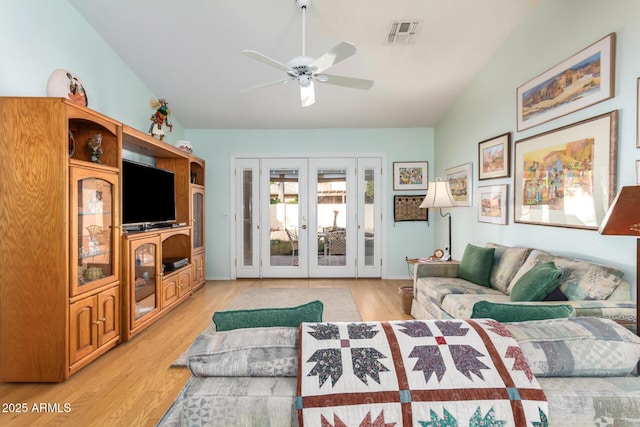 living room with french doors, light hardwood / wood-style floors, ceiling fan, and lofted ceiling