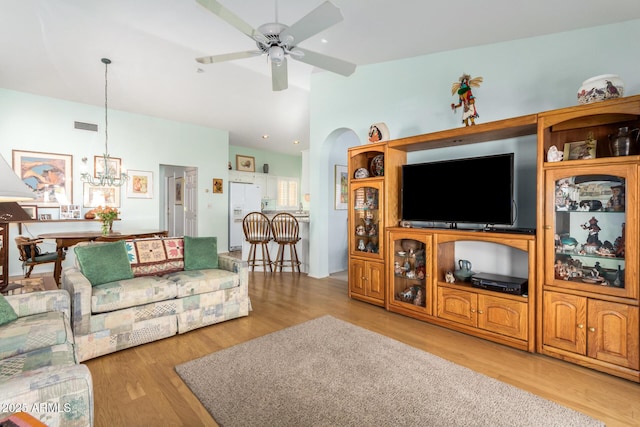 living room featuring ceiling fan with notable chandelier and light hardwood / wood-style floors