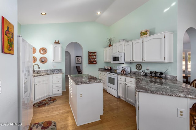 kitchen with a center island, white appliances, white cabinets, sink, and light hardwood / wood-style floors