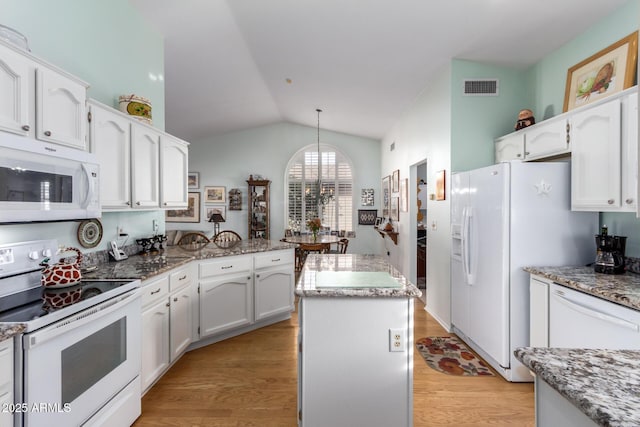 kitchen with white cabinetry, a center island, light hardwood / wood-style floors, vaulted ceiling, and white appliances