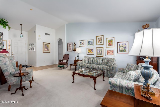 carpeted living room with vaulted ceiling