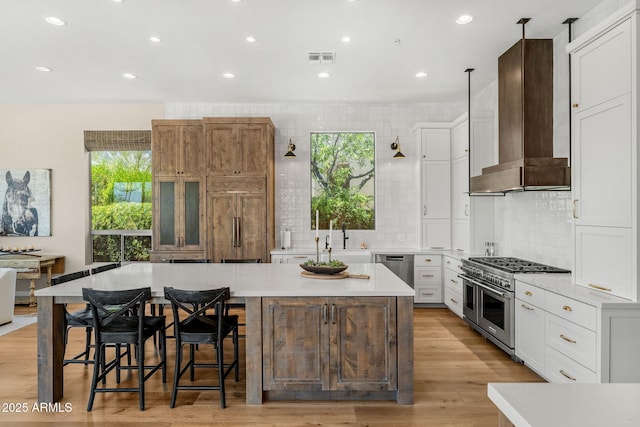11324 E Diamond Cholla Dr, Scottsdale, AZ 85255 - kitchen featuring stainless steel appliances, wall chimney range hood, a kitchen island, light countertops, and recessed lighting