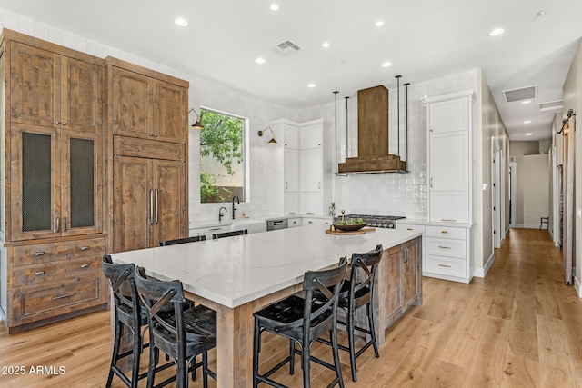 11324 E Diamond Cholla Dr, Scottsdale, AZ 85255 - kitchen featuring premium range hood, a large island, light wood finished floors, recessed lighting, and tasteful backsplash