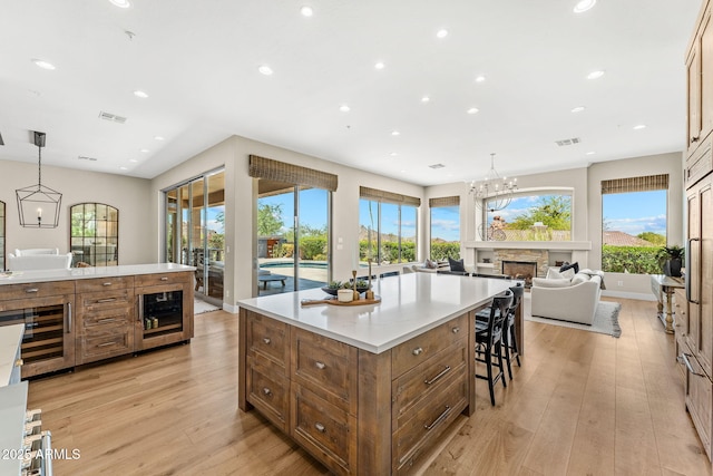 11324 E Diamond Cholla Dr, Scottsdale, AZ 85255 - kitchen featuring wine cooler, brown cabinetry, light wood finished floors, recessed lighting, and light countertops