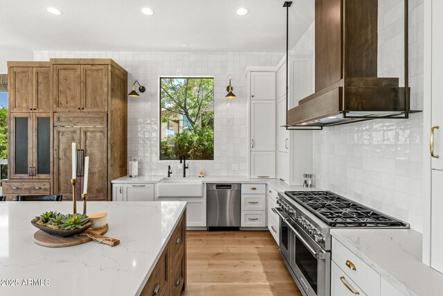 11324 E Diamond Cholla Dr, Scottsdale, AZ 85255 - kitchen featuring wall chimney exhaust hood, stainless steel appliances, a sink, white cabinetry, and decorative backsplash