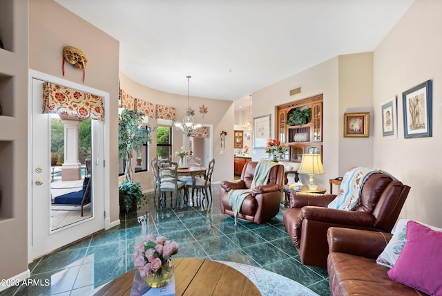 living room with an inviting chandelier and dark tile patterned floors