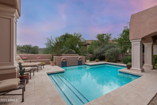 pool at dusk featuring a patio area