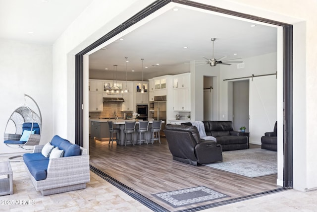 2630 E Lovebird Ln, Gilbert, AZ 85297 - living room with a barn door, a ceiling fan, light wood-style flooring, and recessed lighting