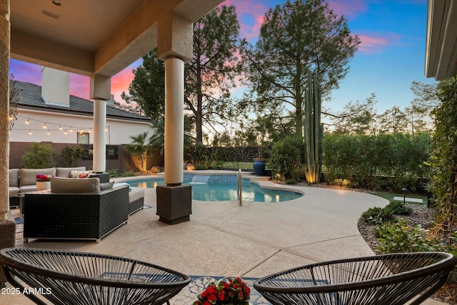 pool at dusk with outdoor lounge area and a patio