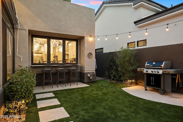 exterior space featuring a yard, exterior bar, and a patio area