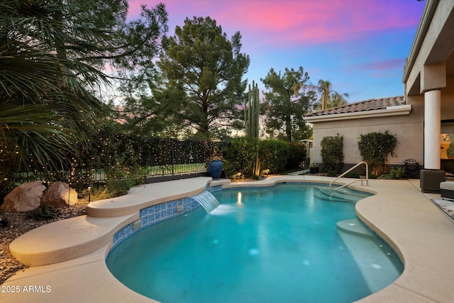 pool at dusk featuring a patio