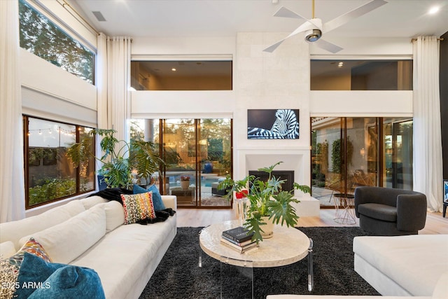 interior space with ceiling fan and a large fireplace