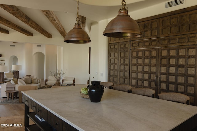 dining space featuring wood-type flooring and beam ceiling