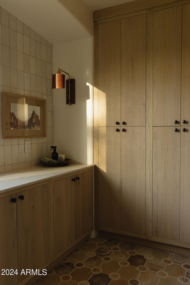 kitchen with dark tile floors and tasteful backsplash