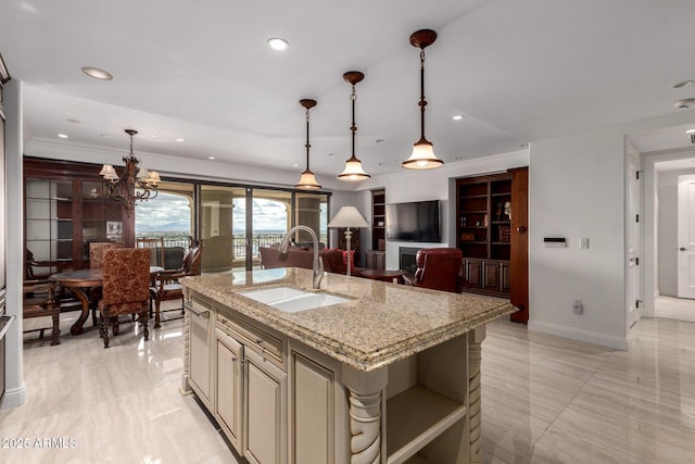 kitchen featuring a kitchen island with sink, cream cabinetry, recessed lighting, and a sink