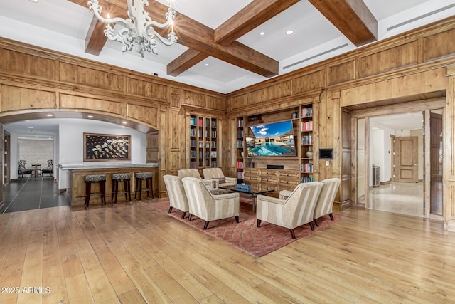 living room with hardwood / wood-style floors, wooden walls, beamed ceiling, and coffered ceiling