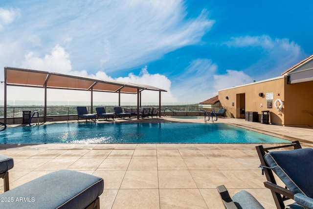 community pool with glass enclosure, a patio, and fence