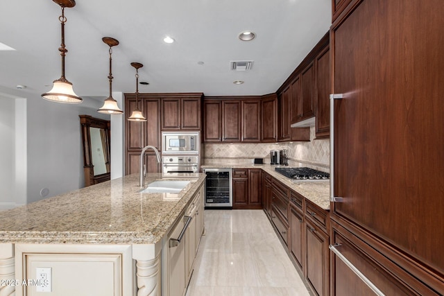 kitchen featuring visible vents, light stone counters, wine cooler, decorative backsplash, and built in appliances