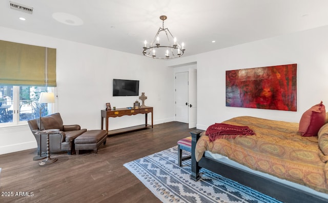 bedroom featuring dark hardwood / wood-style floors and an inviting chandelier