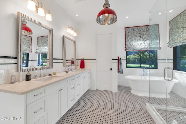 bathroom with tile walls, tile patterned floors, vanity, and separate shower and tub