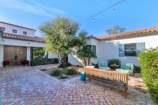 back of property with an outdoor hangout area and a patio