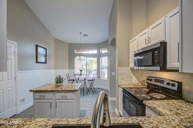 kitchen with white cabinets, hanging light fixtures, range with electric stovetop, and light stone countertops