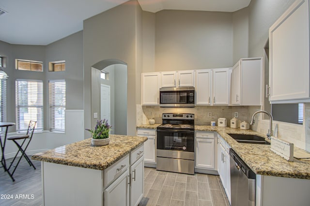 kitchen featuring sink, a kitchen island, white cabinets, and appliances with stainless steel finishes