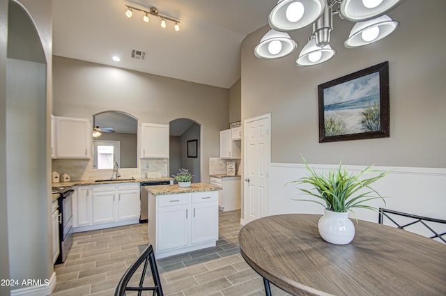 dining space featuring sink and ceiling fan with notable chandelier