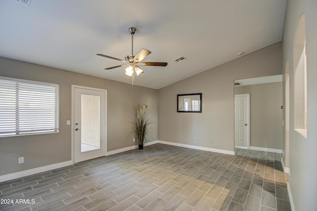 spare room featuring lofted ceiling, light wood-type flooring, and ceiling fan