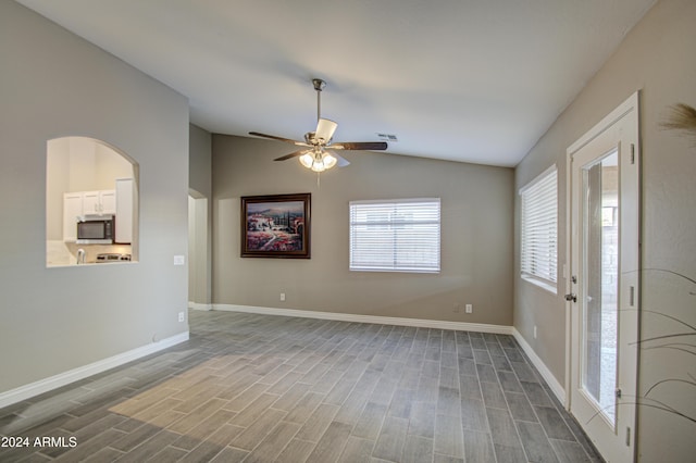 empty room with lofted ceiling, ceiling fan, and wood-type flooring