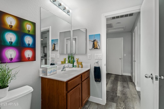 bathroom featuring vanity, hardwood / wood-style flooring, and toilet