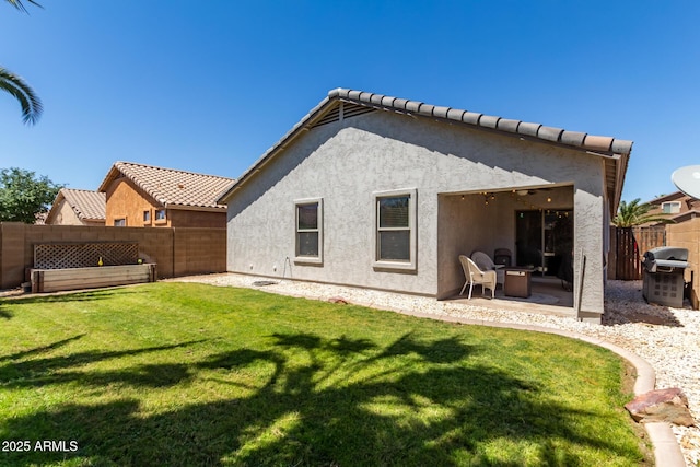 rear view of house featuring a patio area and a yard