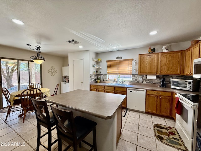 1758 E San Xavier Dr, Casa Grande, AZ 85122 - kitchen with white appliances, a sink, open shelves, brown cabinetry, and backsplash