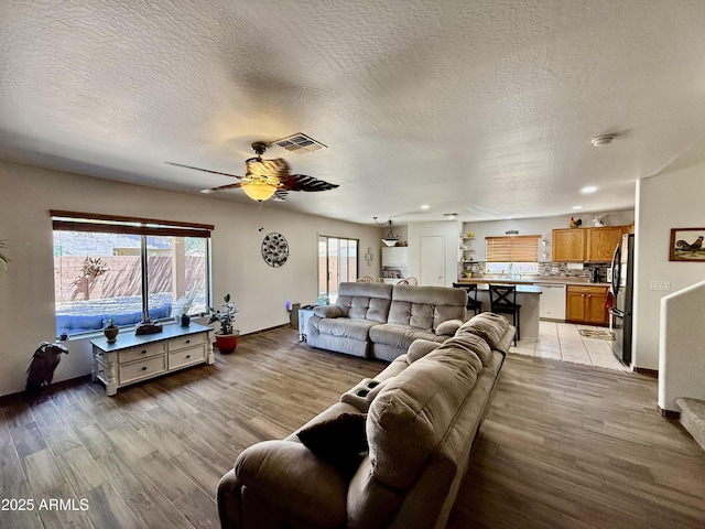 1758 E San Xavier Dr, Casa Grande, AZ 85122 - living area featuring light wood-style flooring, a textured ceiling, ceiling fan, baseboards, and recessed lighting