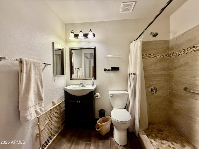 1758 E San Xavier Dr, Casa Grande, AZ 85122 - full bathroom featuring toilet, tiled shower, vanity, wood finished floors, and a textured wall