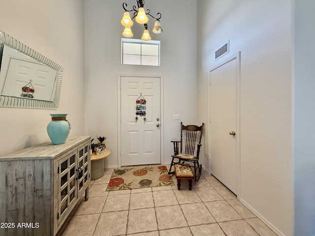 1758 E San Xavier Dr, Casa Grande, AZ 85122 - foyer entrance with a high ceiling, a chandelier, light tile patterned floors, and baseboards