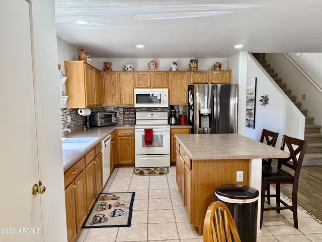 1758 E San Xavier Dr, Casa Grande, AZ 85122 - kitchen with white appliances, a sink, decorative backsplash, a breakfast bar, and recessed lighting